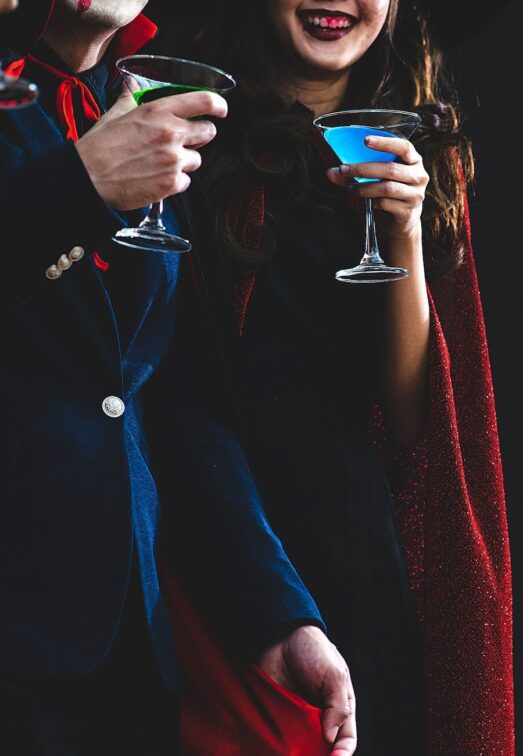 Couple in Dracula Costumes drinking cocktails